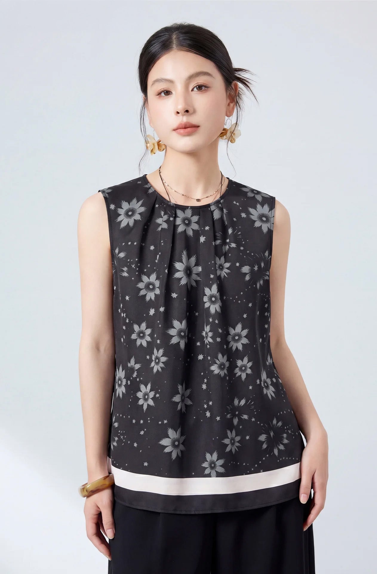 Full front view of a model posing in a loose-fitting pleated mulberry silk blouse in Muted Sundrop — From Borcelleclothes.