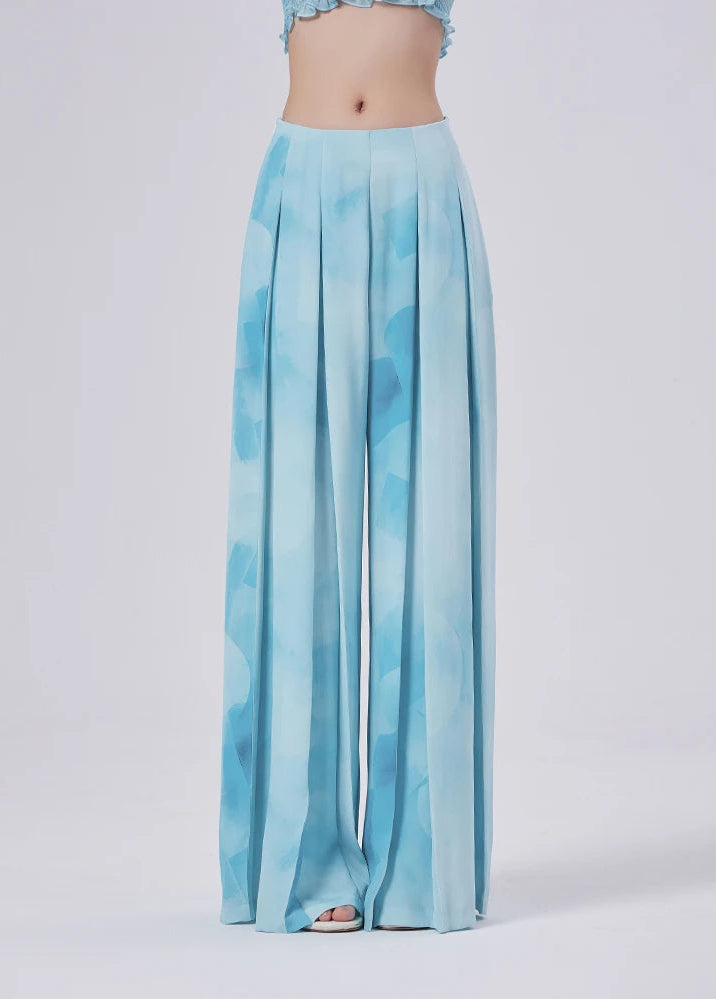 Floor-length silhouette standing still, where watercolor azure turns fabric into open sky — From Borcelleclothes.