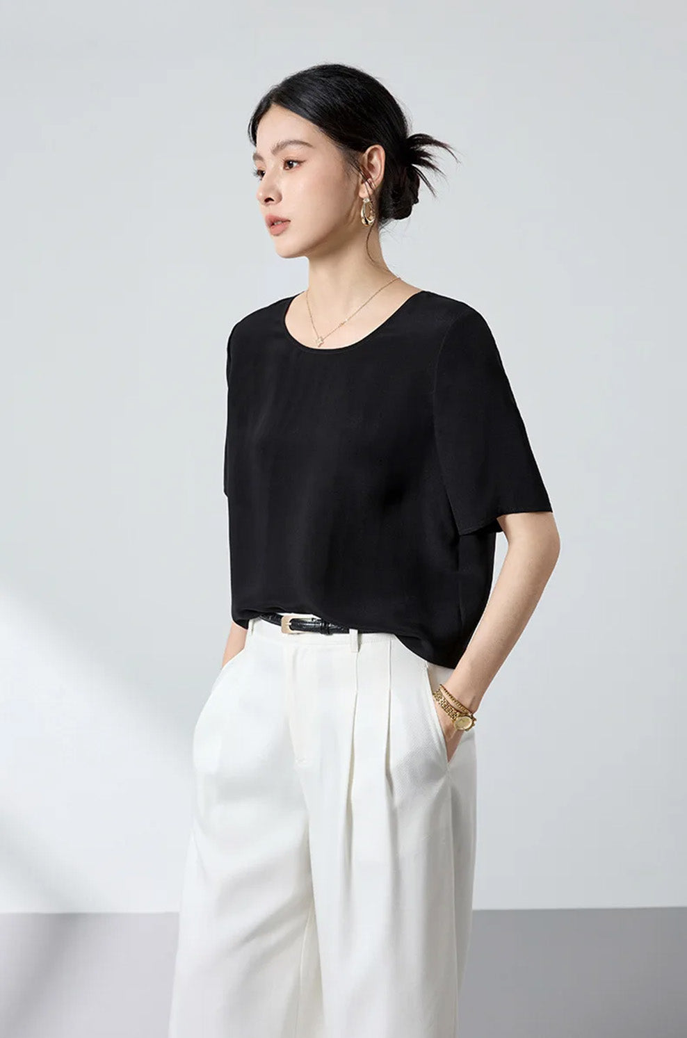 Three-quarter side angle showing the fluid profile, set-in sleeve structure, and relaxed body of the black matte silk crepe top — From Borcelleclothes.