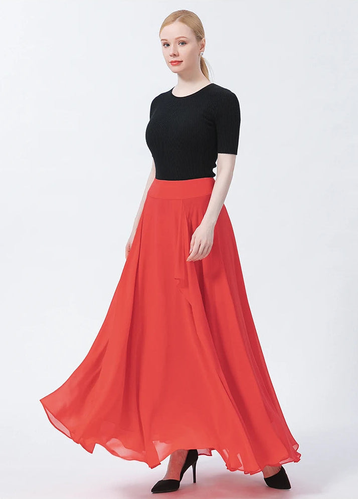A model swirling to the right, demonstrating the lightweight, flying volume of the red-pink silk georgette skirt — From Borcelleclothes.