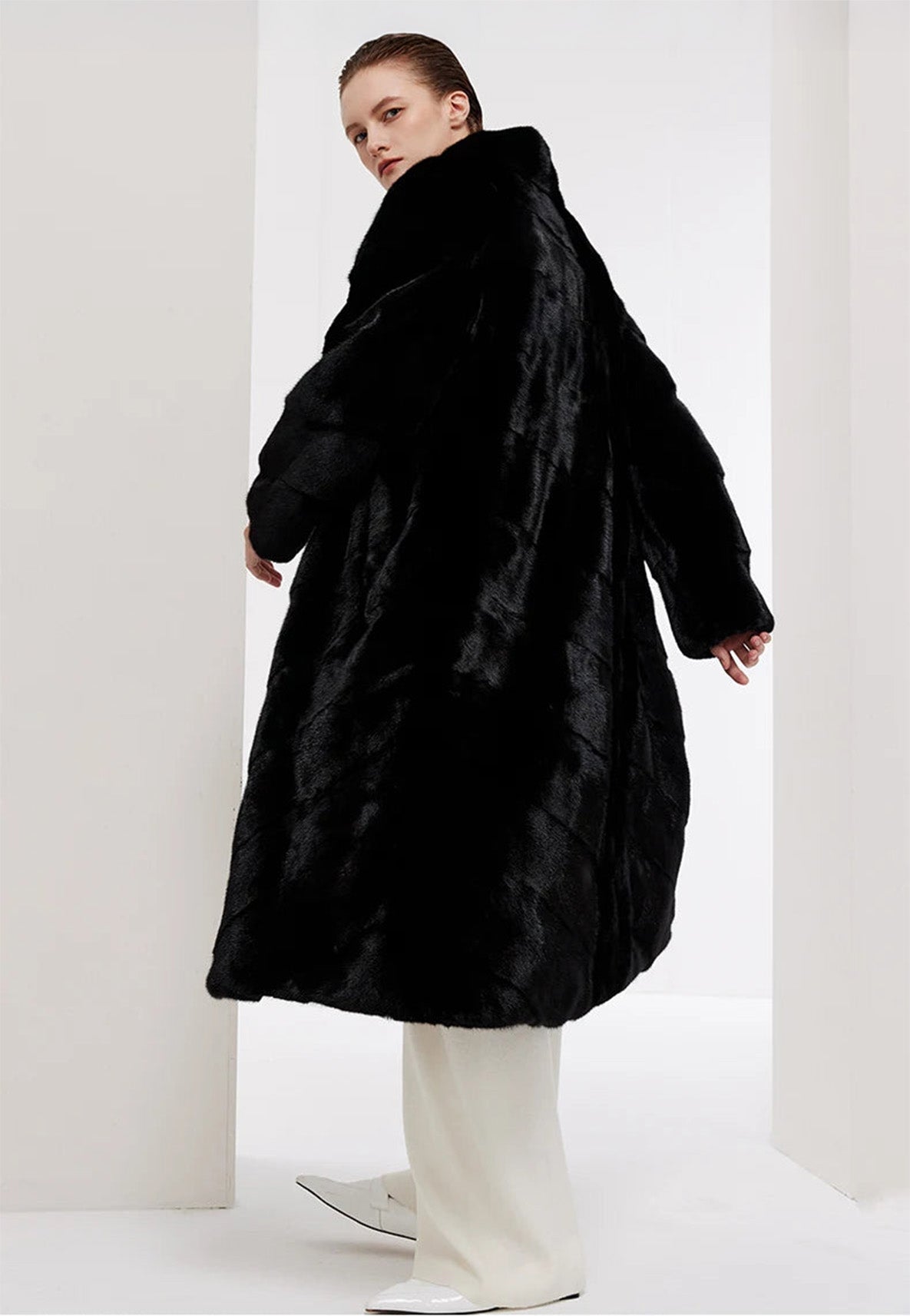 Women’s chevron sheared mink coat in Beyond Black, model swirling from the back — From Borcelleclothes.