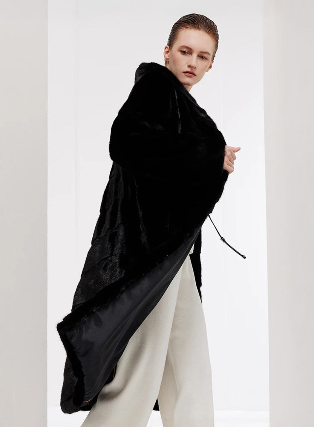 Women’s chevron sheared mink coat in Beyond Black, model swirling with visible motion in the hem — From Borcelleclothes.