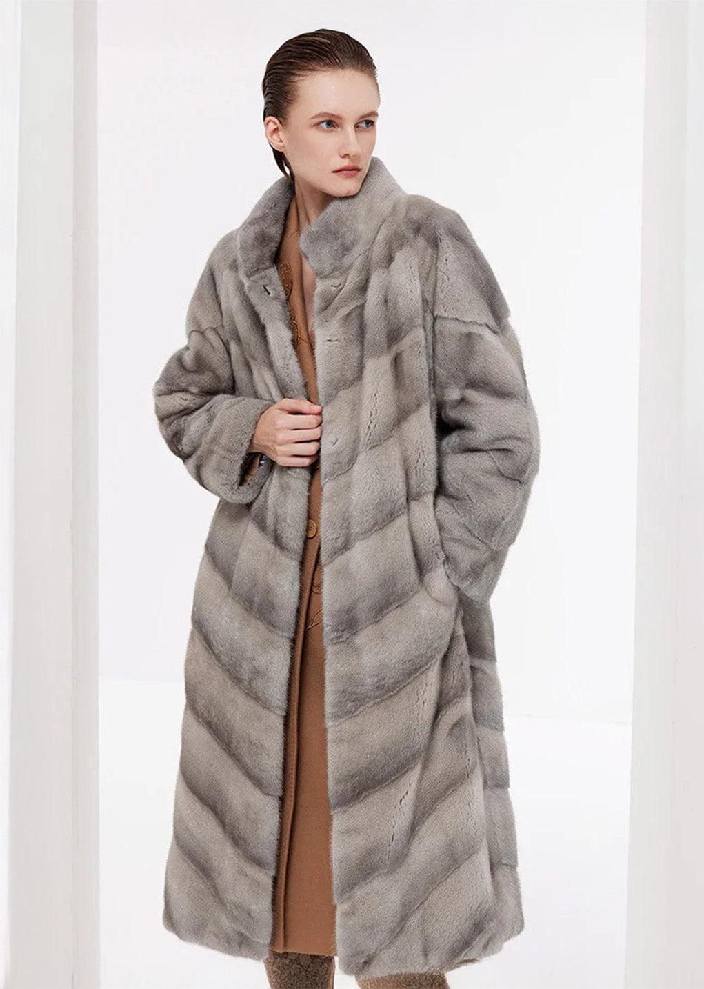 Women’s chevron sheared mink coat in Call of the Loon, unfastened, model holding the front edge — From Borcelleclothes.