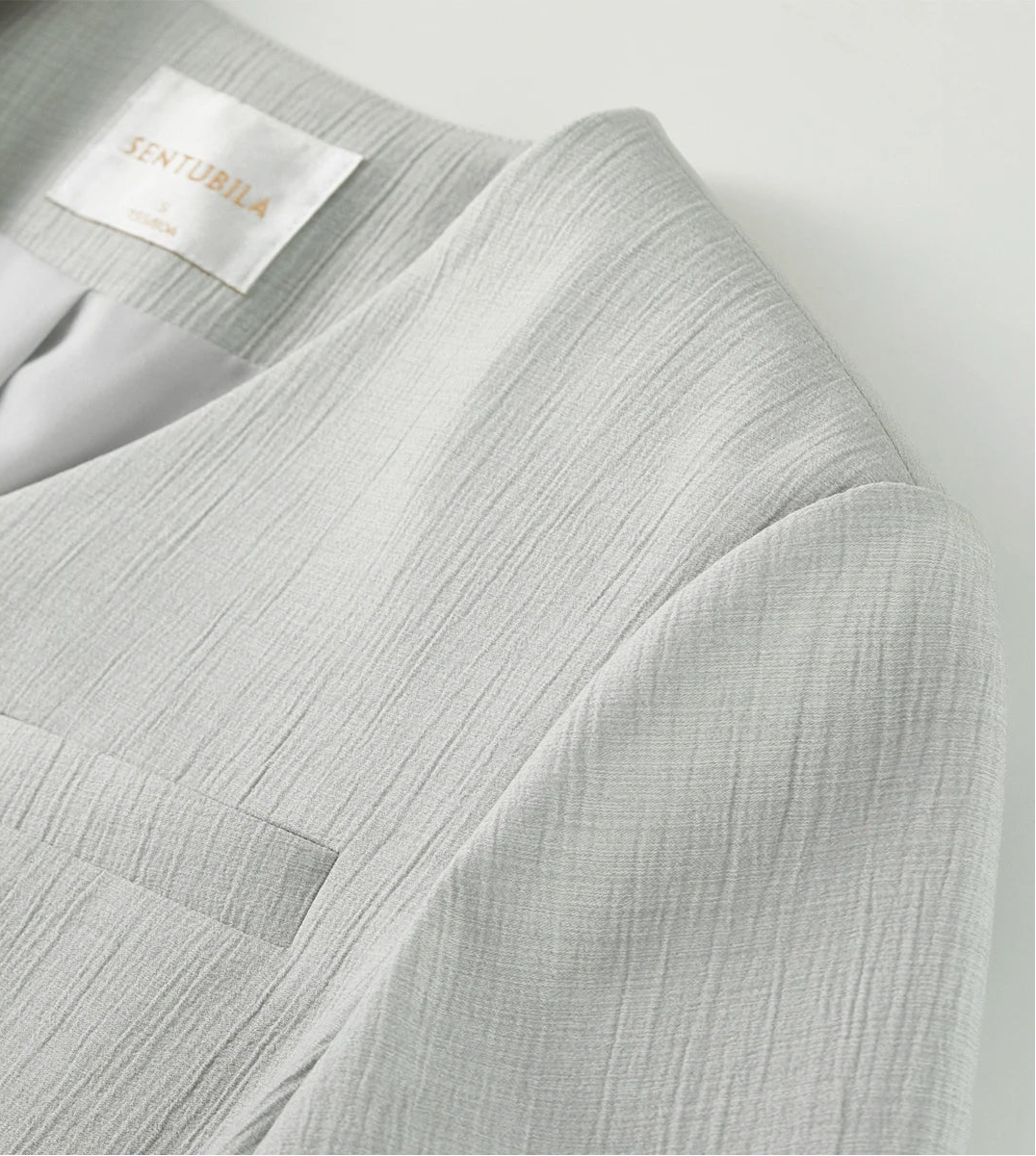 Detailed view of the structured jacket shoulder and set-in sleeve of the Named by Frost viscose set. From Borcelleclothes.