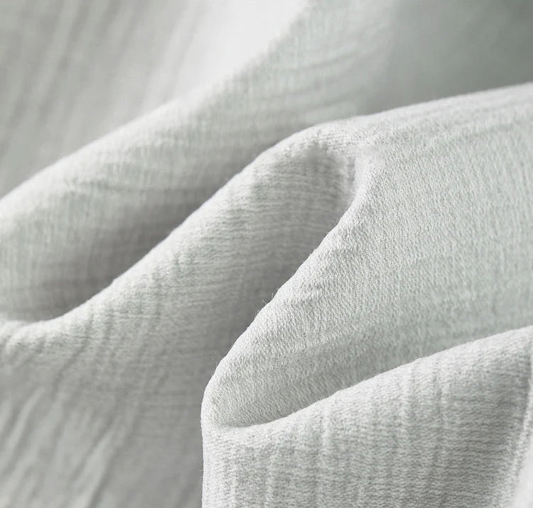 Close-up of the wave-folded, grainy texture of the Named by Frost viscose fabric in a cool sage-grey shade. From Borcelleclothes.