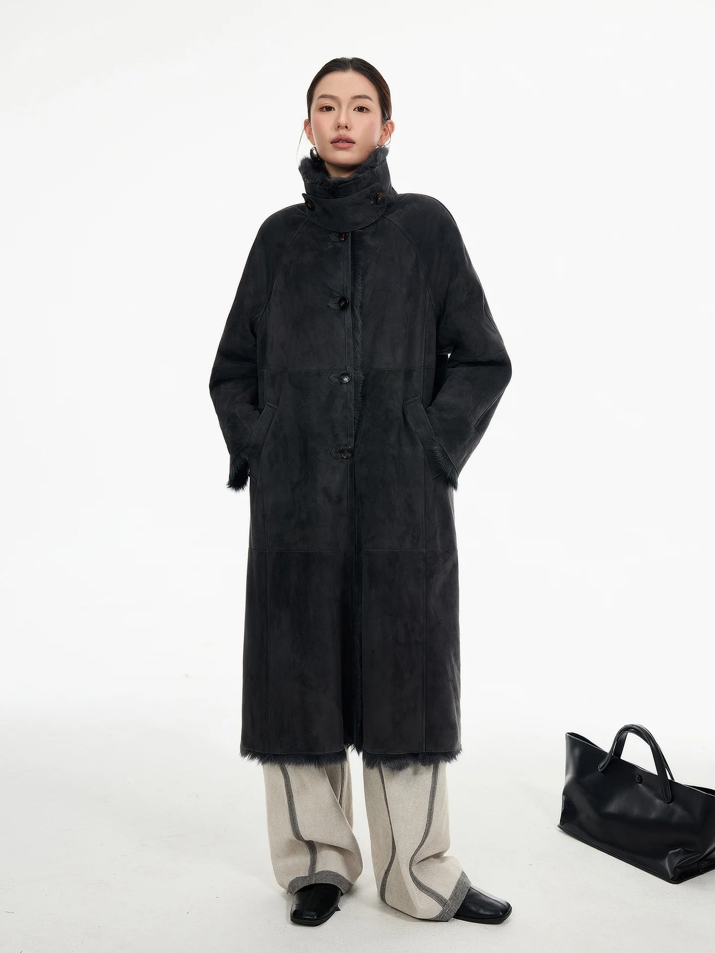 Model in goatskin coat in Tusch standing with hands in diagonally set welt pockets, showing the natural drape of the double-faced leather — From Borcelleclothes.