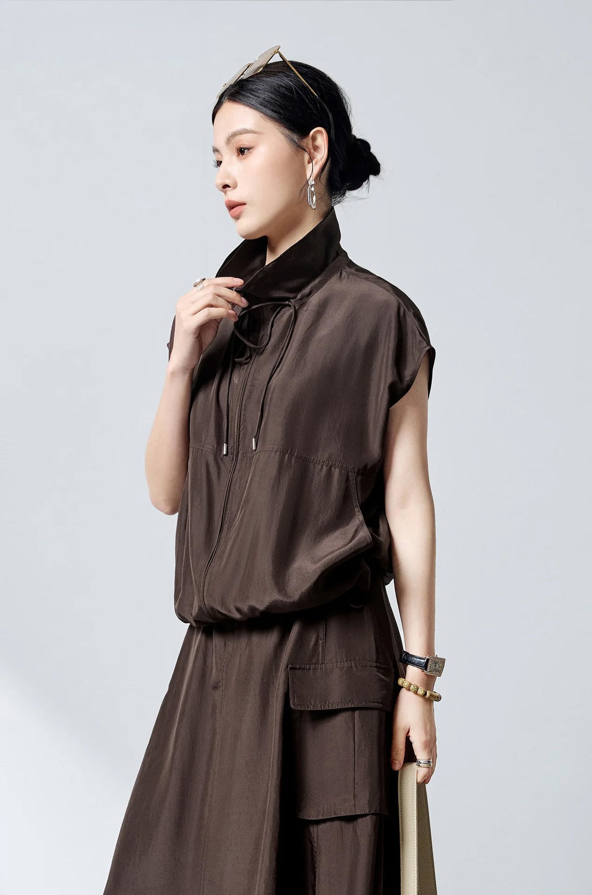 Model touching zipped convertible collar of Mulberry silk blouson in Bitter Chocolate — From Borcelleclothes.
