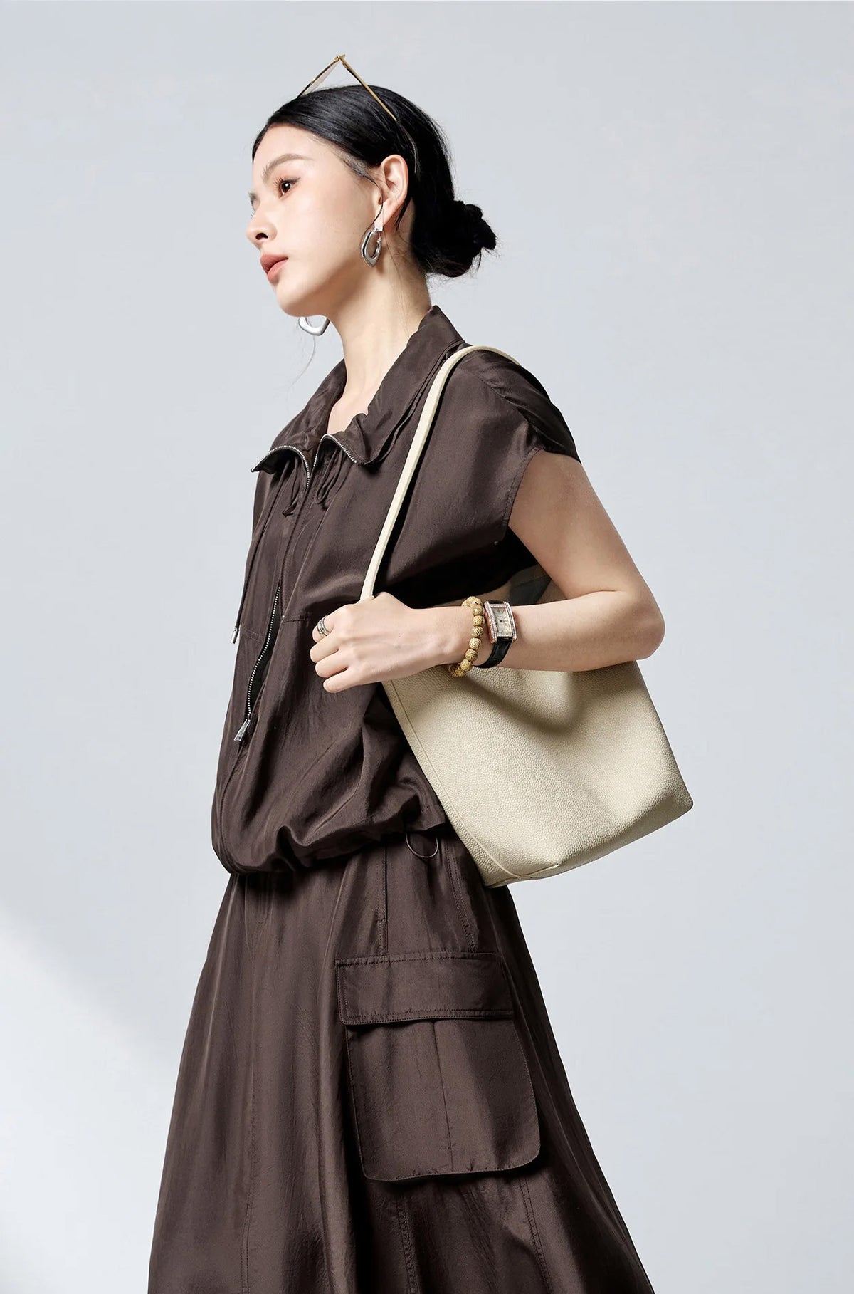 Side profile of model walking in Bitter Chocolate Habotai silk blouson — From Borcelleclothes.