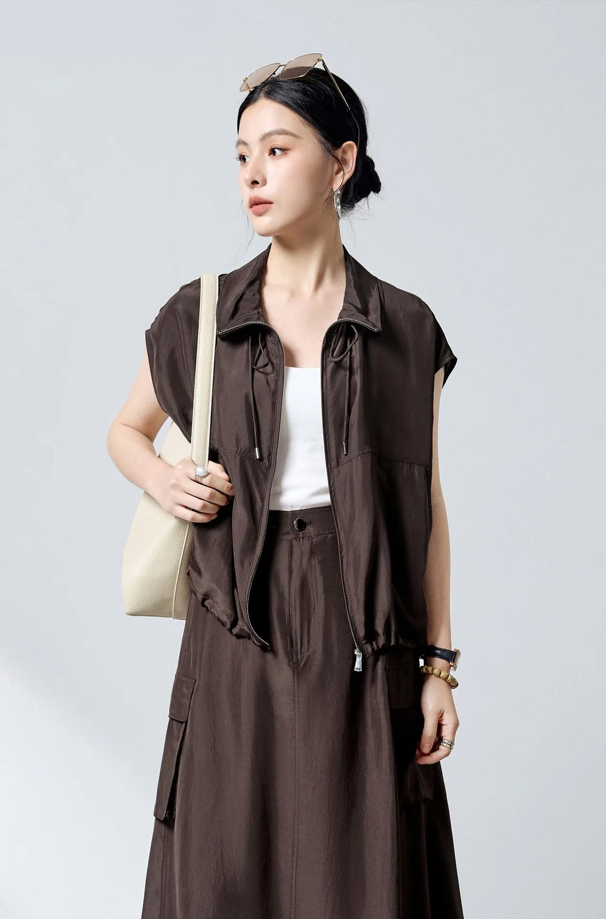 Model wearing unzipped silk blouson with bag over shoulder — From Borcelleclothes.
