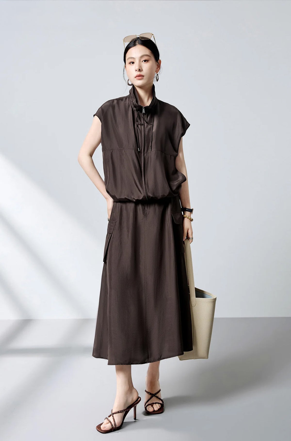 Model in zipped Mulberry silk blouson holding bag with hand on hip — From Borcelleclothes.