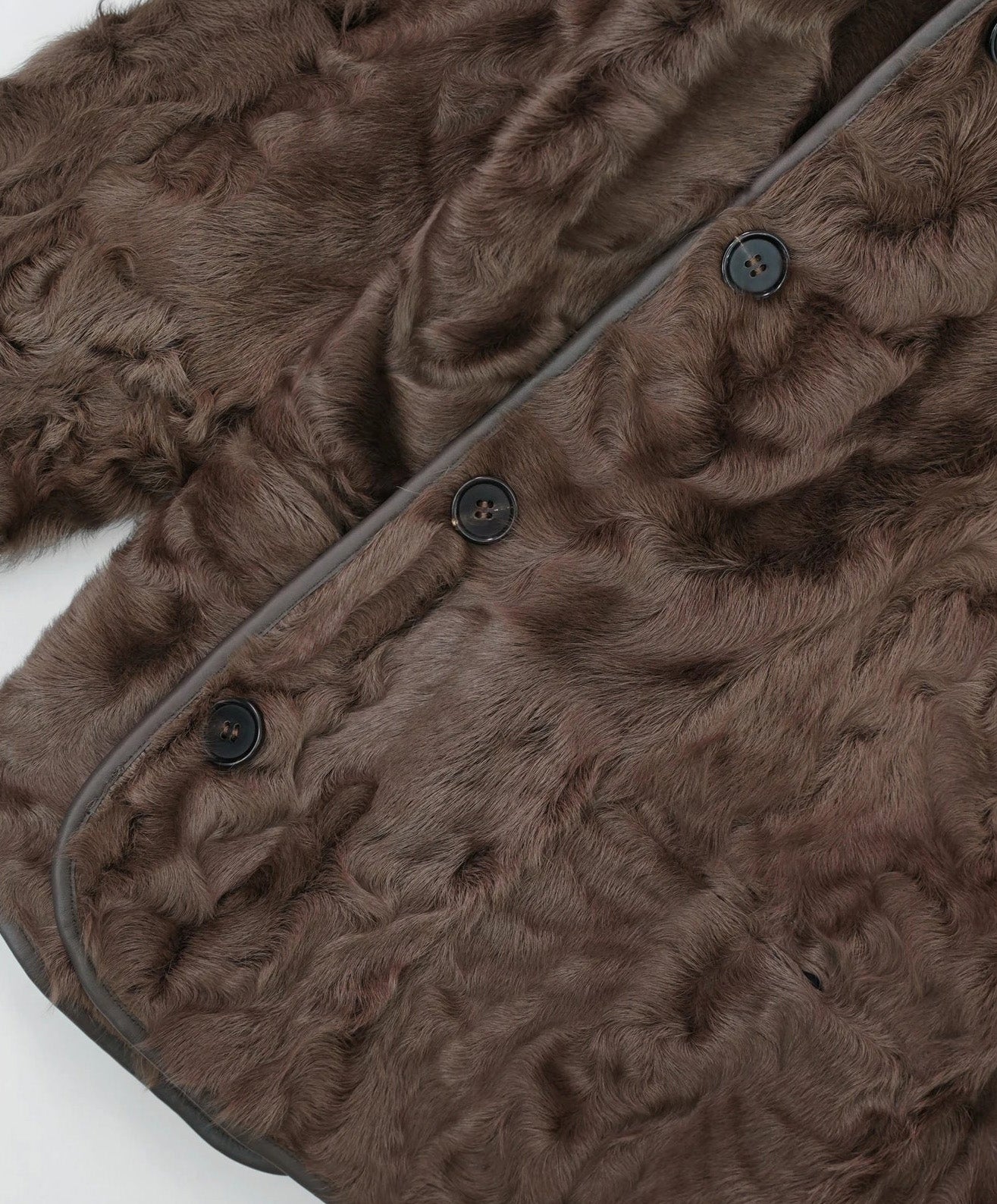 Close view of the lower section of the Clove Ripples shearling coat, fur side out, highlighting volume and softness — From Borcelleclothes.