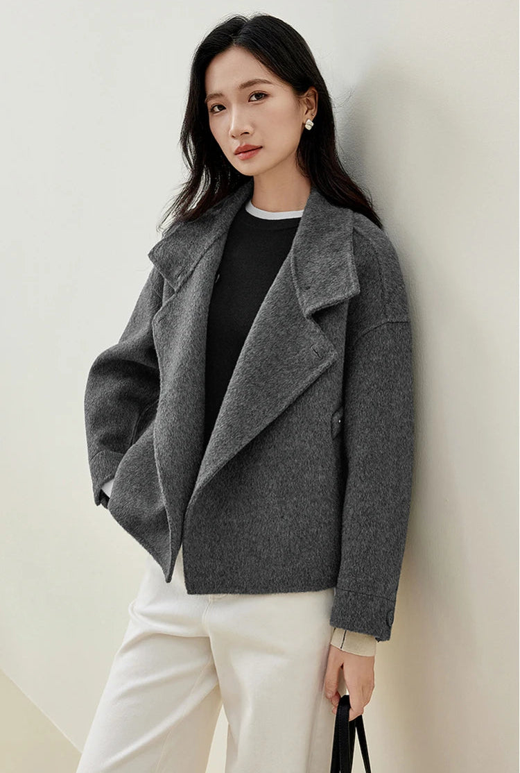 A woman holding a bag, her jacket unfastened to reveal the relaxed Equilibrium silhouette. — From Borcelleclothes.