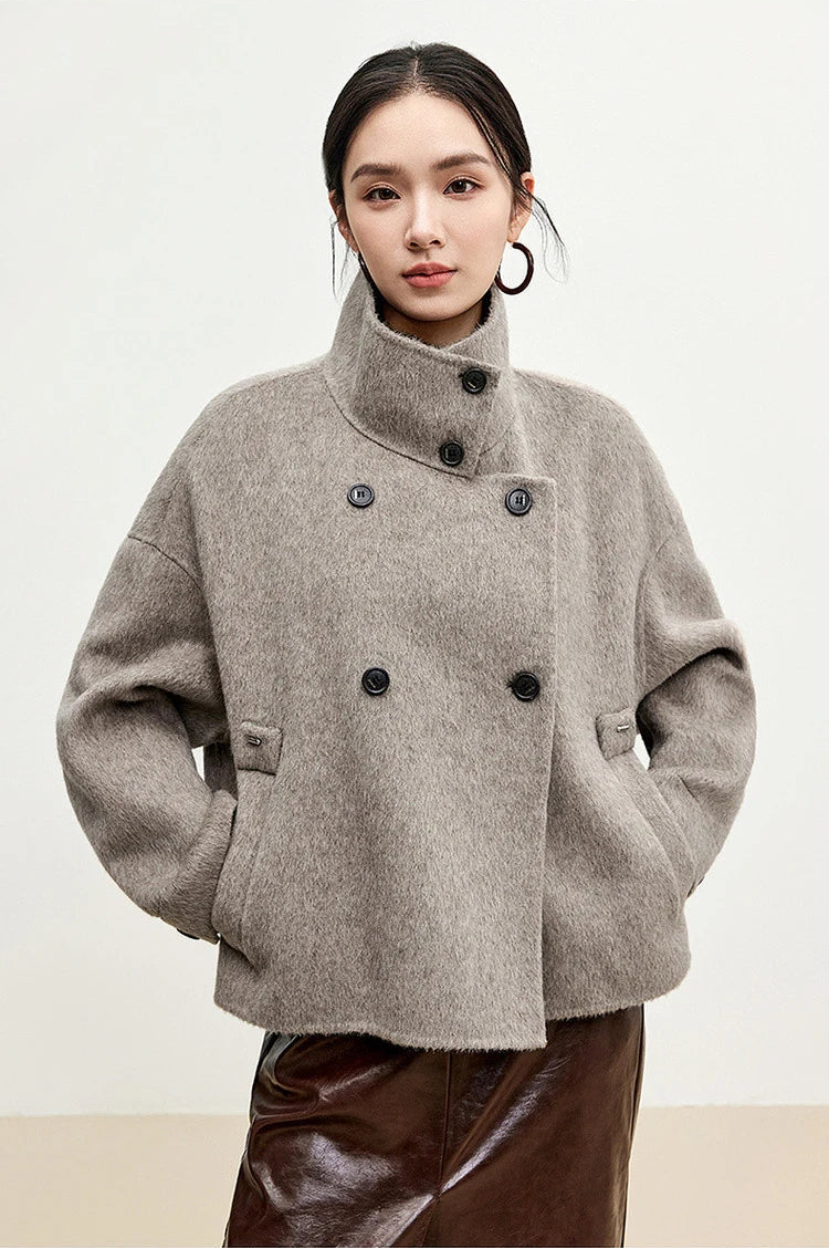 A woman resting her hands in the pockets of the wool jacket in Gravity color.— From Borcelleclothes.