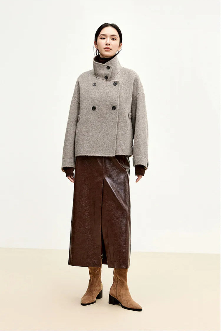 The power of a closed silhouette — a woman standing tall, shielded by the architectural high-neck design. — From Borcelleclothes.