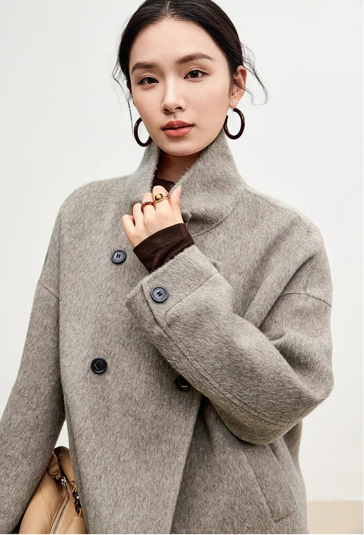 The intersection of daily life and high design — a woman prepared for the world, feeling the texture of her coat. — From Borcelleclothes.