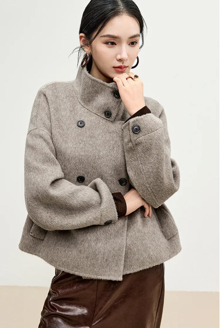 The silhouette of a woman in profile, her hand resting on the architectural collar, lost in a moment of quiet Presence. — From Borcelleclothes.