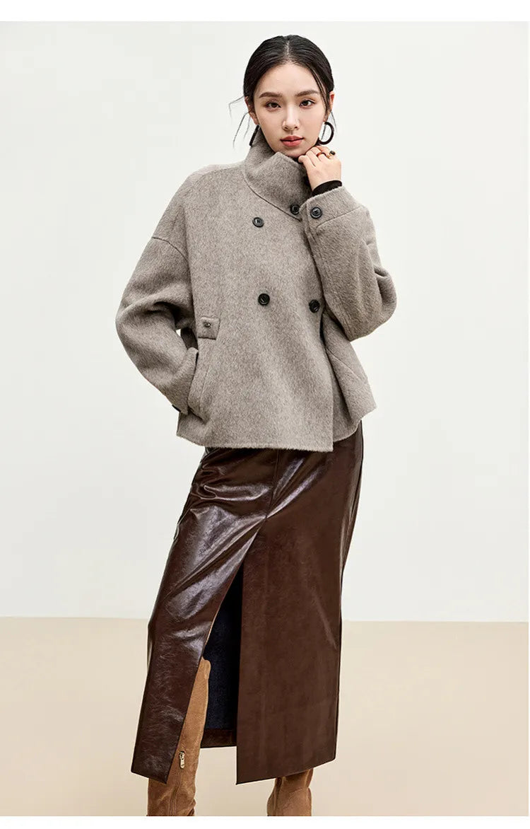 A woman’s gentle gesture as she adjusts the high-fastened collar, embodying the focused energy of the Gravity model. — From Borcelleclothes.