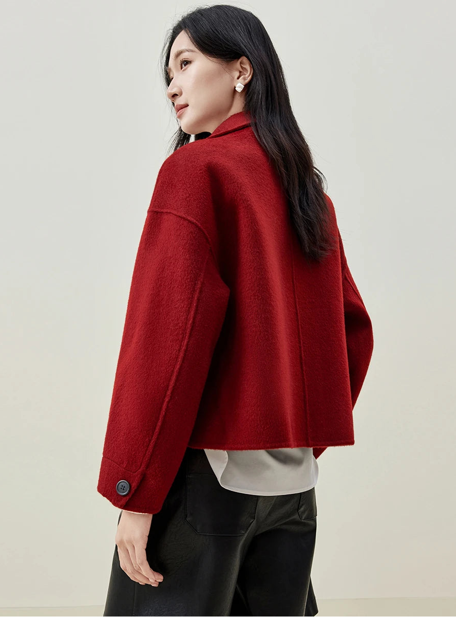 The architectural strength of the jacket as seen from behind, framing the woman’s form in bold Red Resonance. — From Borcelleclothes.