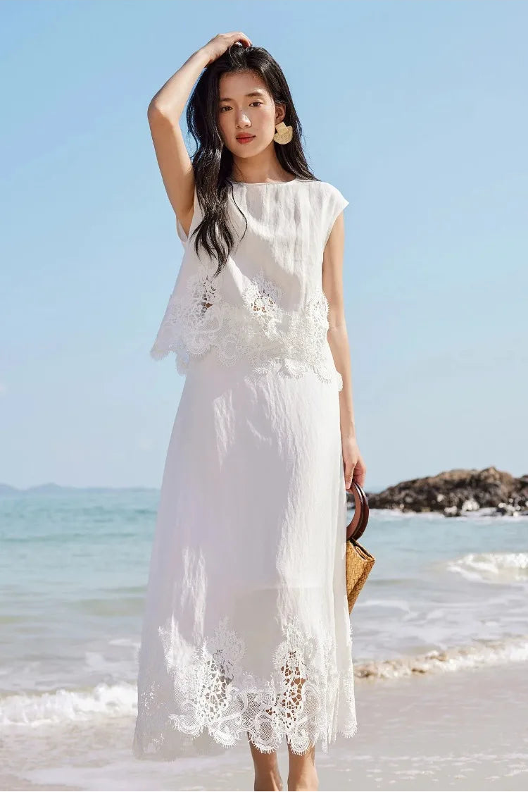 A woman holding a bag and adjusting her hair, dressed in the Foam Kiss linen set. — From Borcelleclothes.