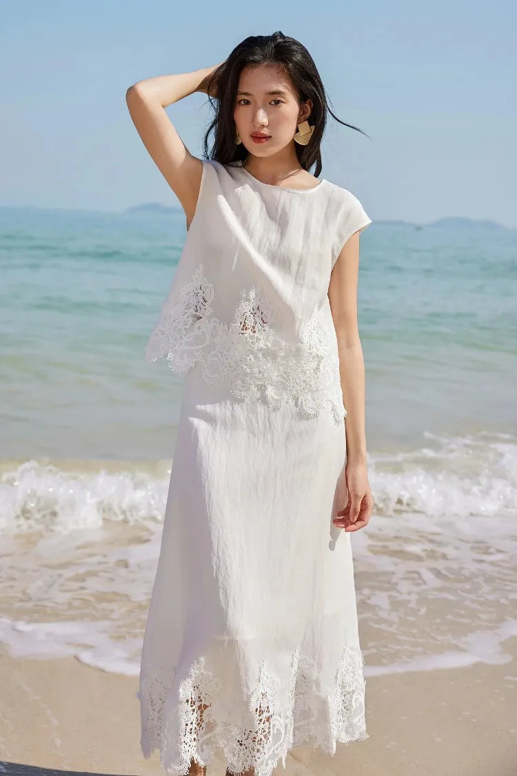 A woman adjusting her hair while wearing the Foam Kiss corded lace two-piece set on the beach. — From Borcelleclothes.