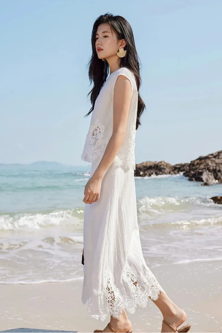 A woman walking along the shore in the Foam Kiss corded lace linen set. — From Borcelleclothes.