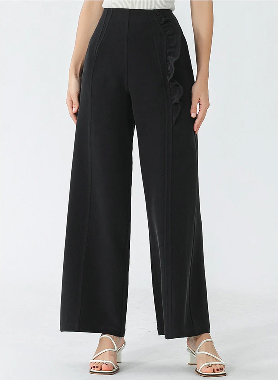Front view of women's Mulberry silk trousers showcasing asymmetrical waist inserts and ruffle detail — From Borcelleclothes.