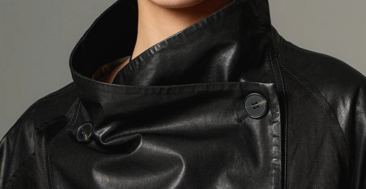 Full-length portrait of the black cowhide jacket in Beneath the Mask, with the generous collar buttoned high into a strict stand silhouette. — From Borcelleclothes.