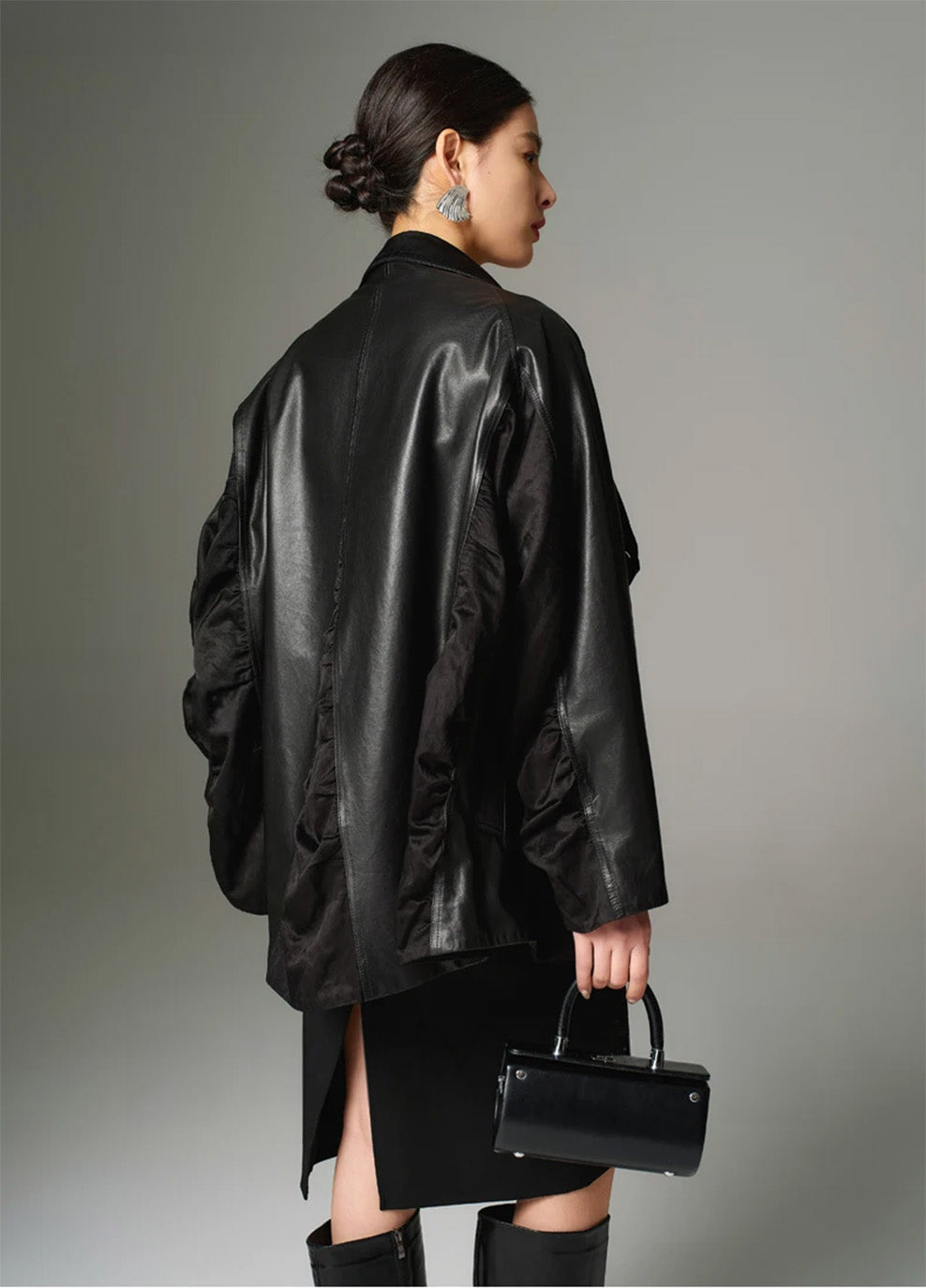 A back view of the Beneath the Mask sculptural jacket, showing the central padded wedge dropping from the waistline and flaring the back panels into a short train. — From Borcelleclothes.