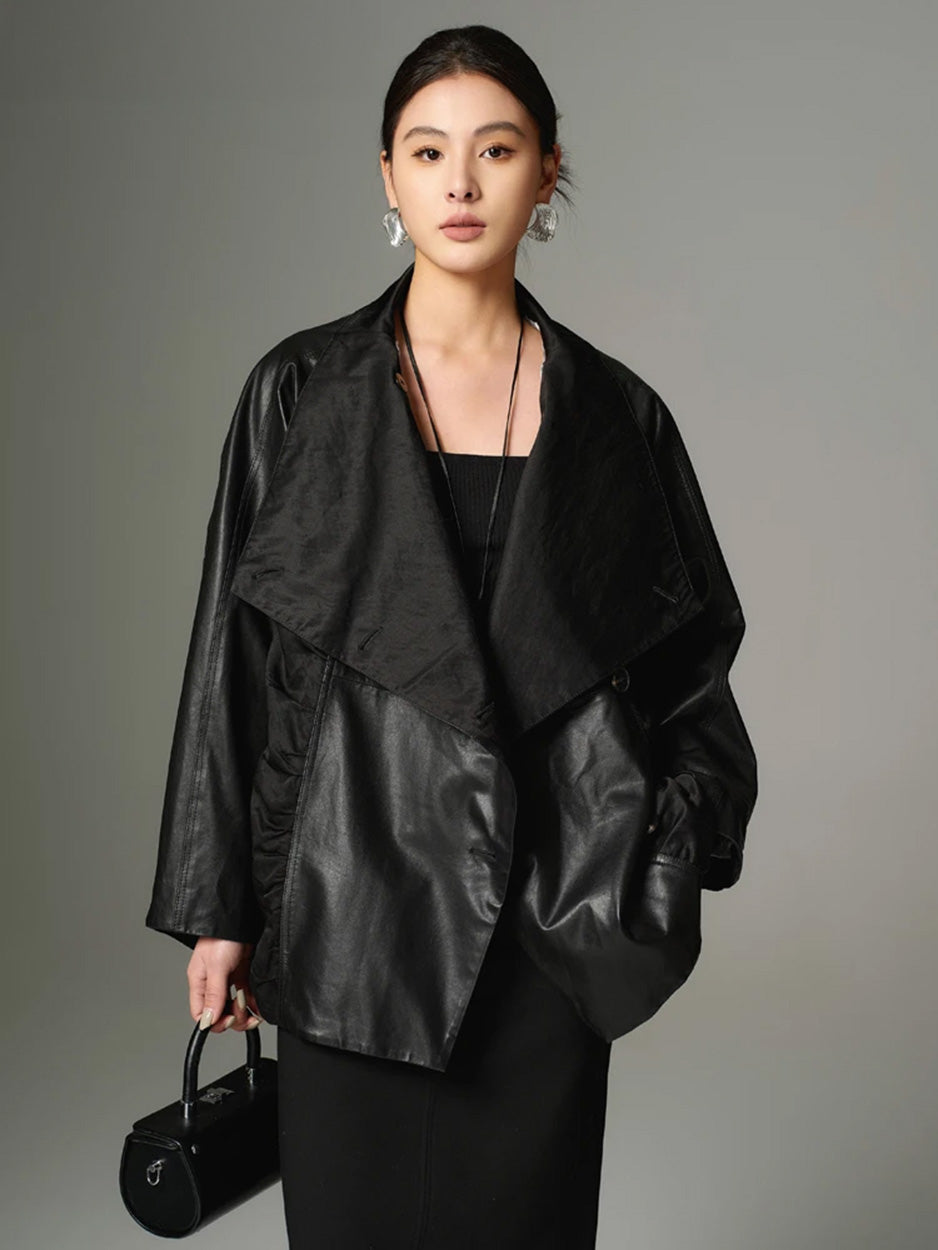 Full-length portrait of a model looking forward, demonstrating the fluid, asymmetrical drape of the unfastened architectural jacket. — From Borcelleclothes.