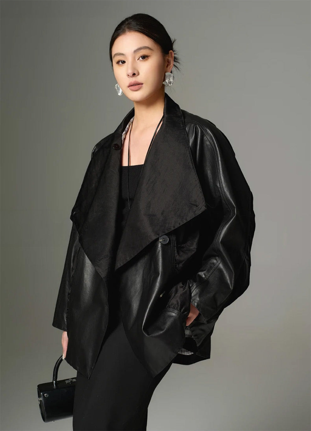 A side view profile of the Beneath the Mask cowhide jacket, emphasizing the deep folds of the open front panel and the high-buttoned placket. — From Borcelleclothes.