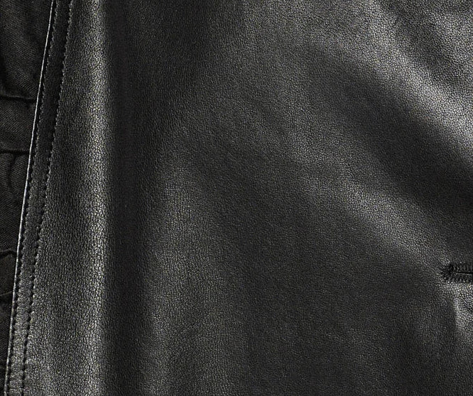 Macro photography of the cowhide leather grain against the velvety matte texture of the memory-wire ruched wedges. — From Borcelleclothes.