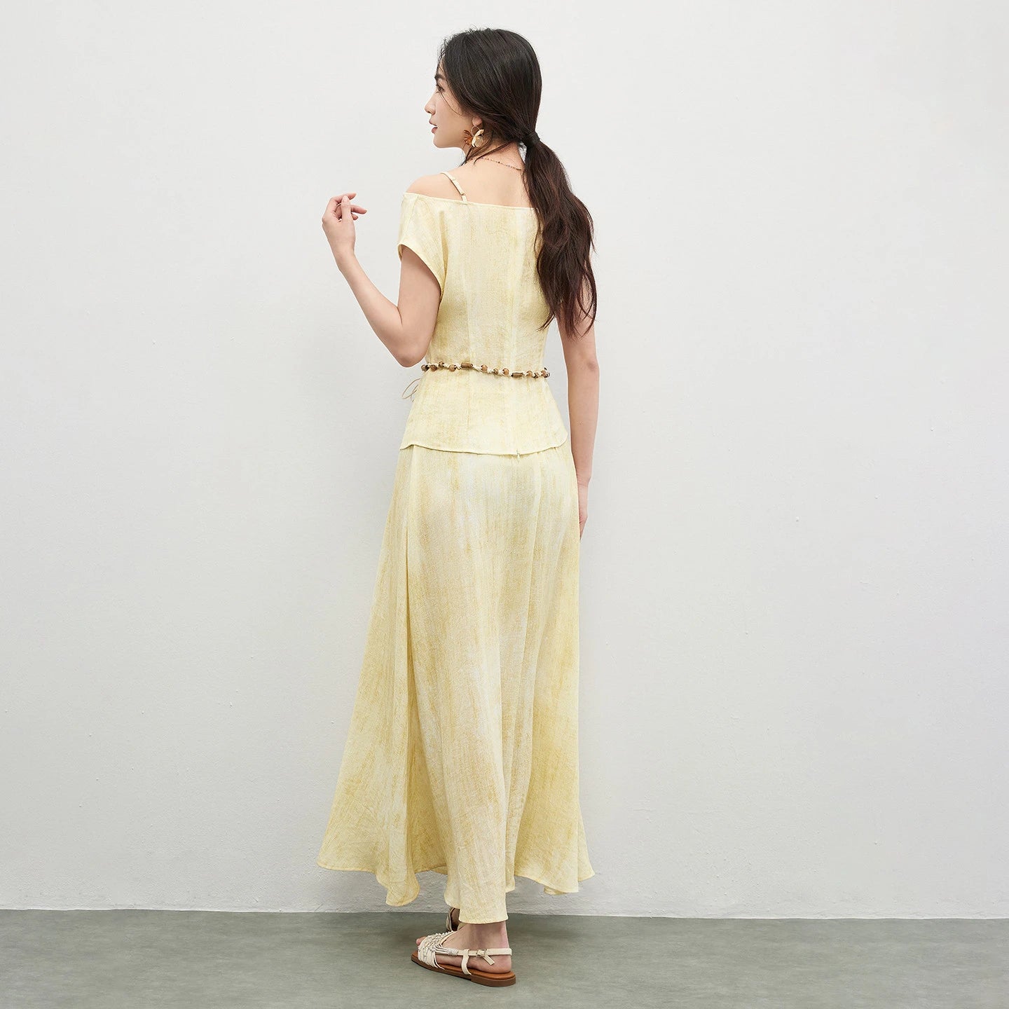 View of a woman from the back, showing the unique open-back feel and shorter hemline of the top — From Borcelleclothes.