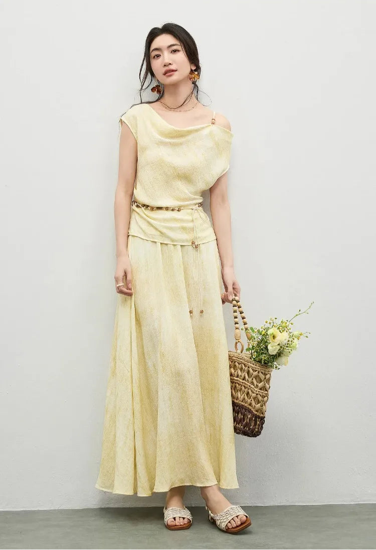 A woman posing with crossed legs and holding a bag, highlighting the flow of the flared midi skirt — From Borcelleclothes.