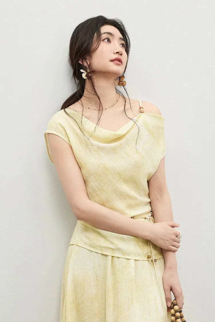 A serene woman in the Urban Hippolita set touching her forearm and looking up, capturing the "distant island" mood — From Borcelleclothes.