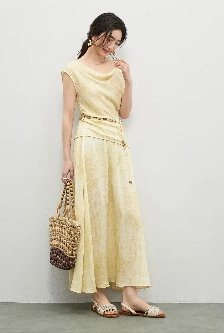 A feminine moment of a woman touching a strand of hair, showcasing the delicate beaded strap of the top — From Borcelleclothes.