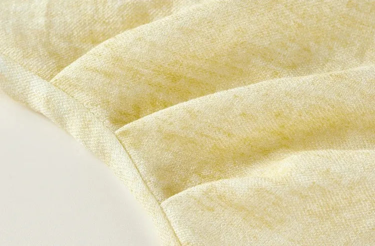 Detailed view of the three waist pleats that create the signature asymmetrical drape — From Borcelleclothes.
