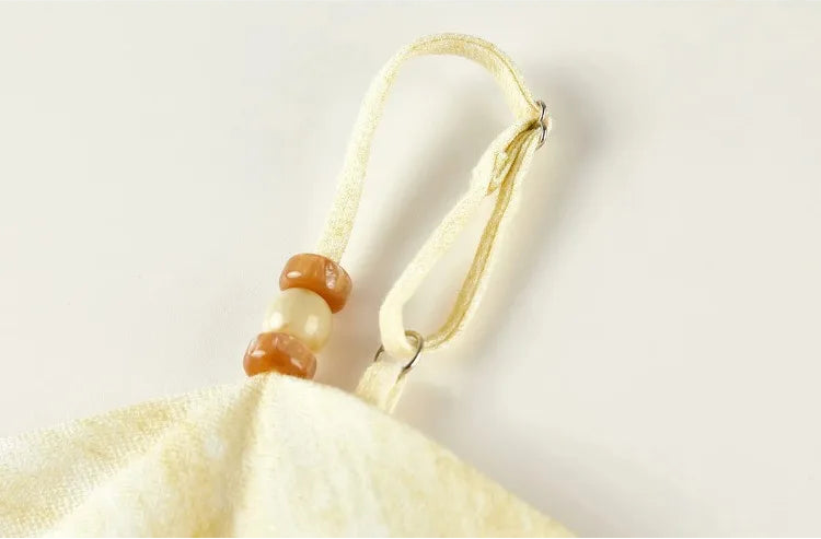 Macro shot of the adjustable shoulder strap accented with honey-toned beads — From Borcelleclothes.
