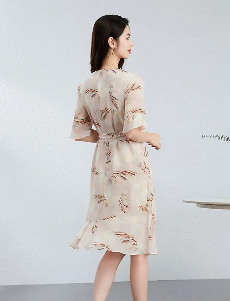 Rear view of the silk dress, revealing the elegant low-high diagonal flounce that creates a spiral rhythm with every step — From Borcelleclothes.