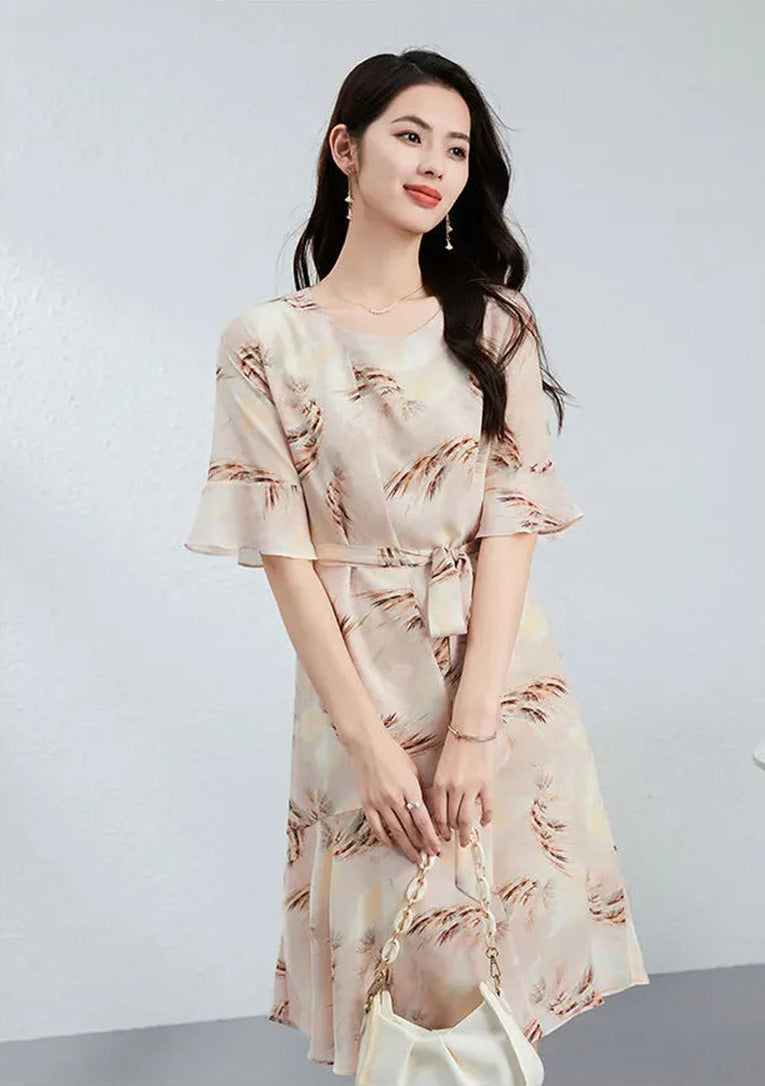 A fleeting profile of a woman captured in movement, highlighting the airy flounce cuffs and the poetic nature-inspired print — From Borcelleclothes.