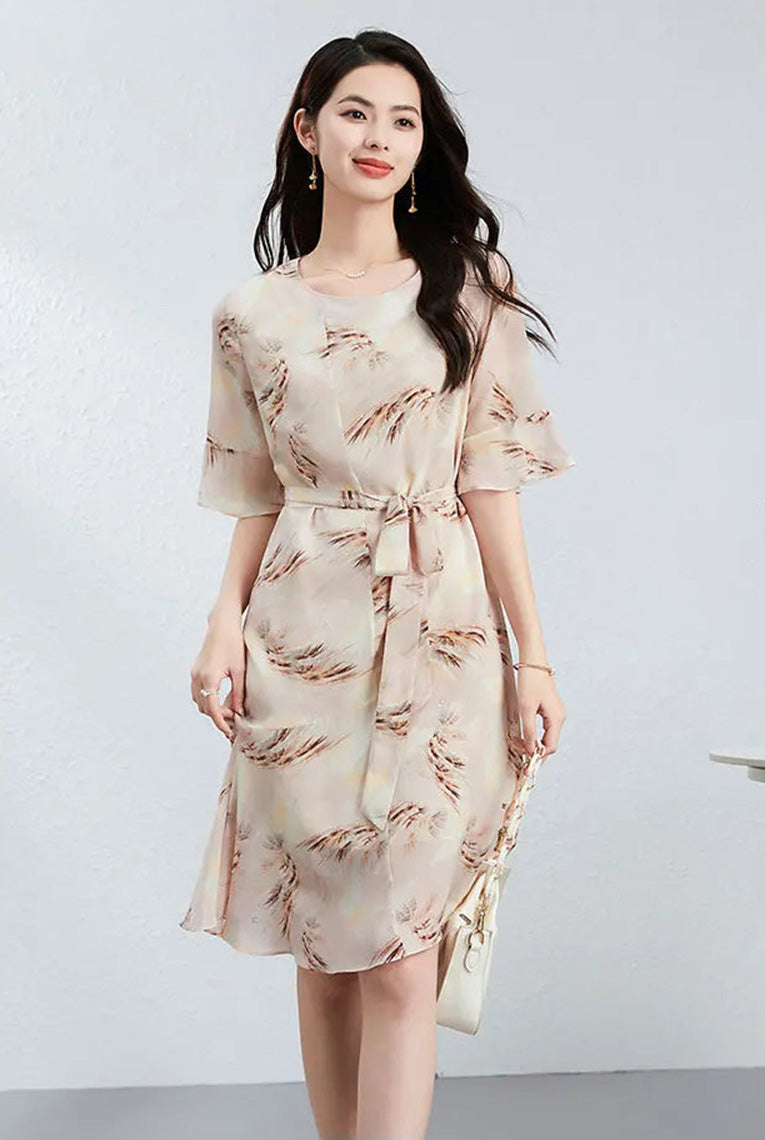 A graceful silhouette of a woman in a silk flounce dress, perfectly accessorized with a minimalist white bag for a modern city look — From Borcelleclothes.