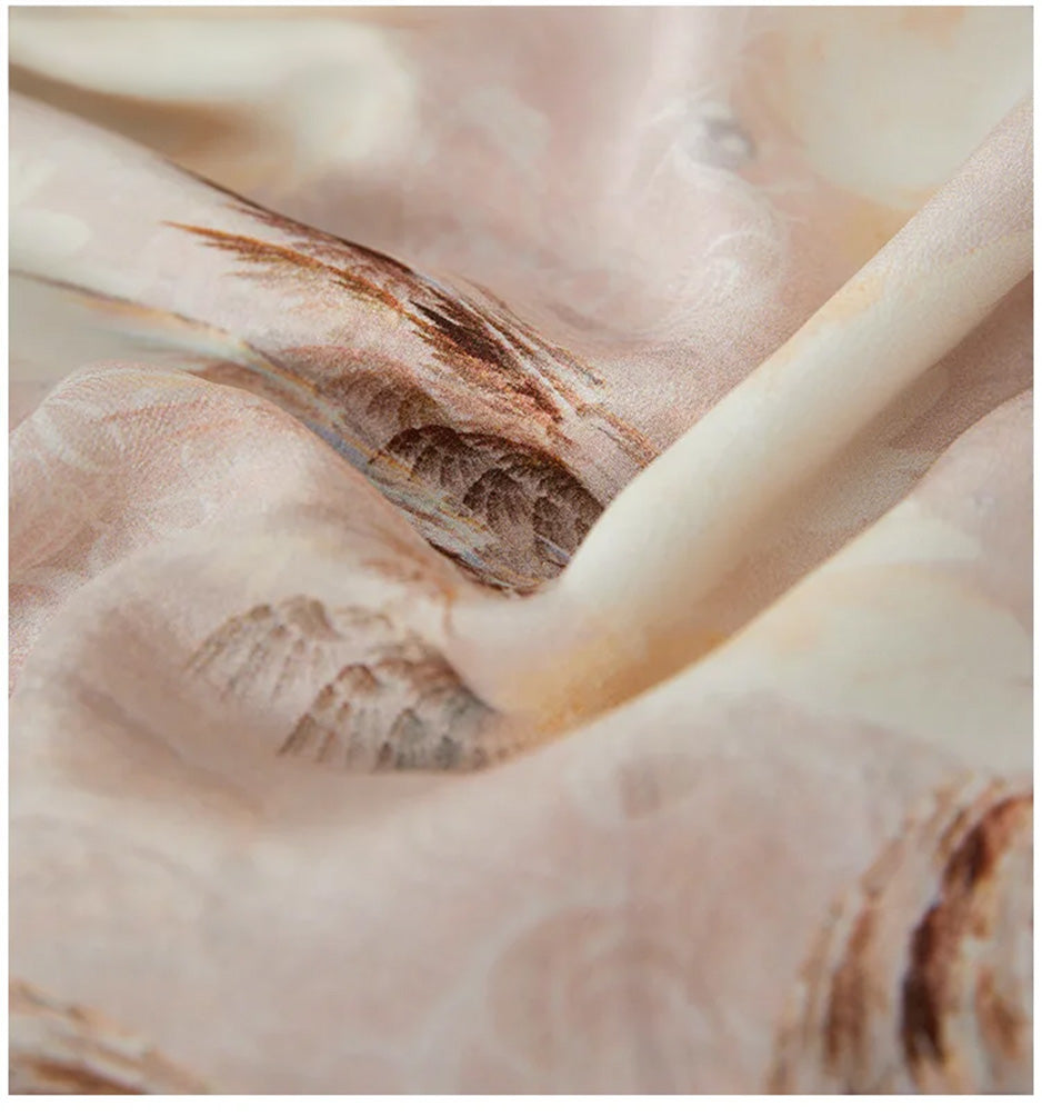 Close-up of the "First Light" nature-inspired silk, showcasing the soft wave-like folds and the ethereal print of butterflies and morning dew — From Borcelleclothes.