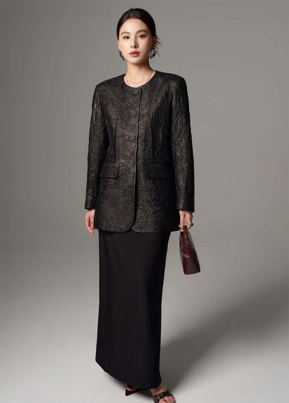 Full-length view of a model in a fully buttoned crinkled sheepskin jacket in Crinkled Nocturne — From Borcelleclothes.