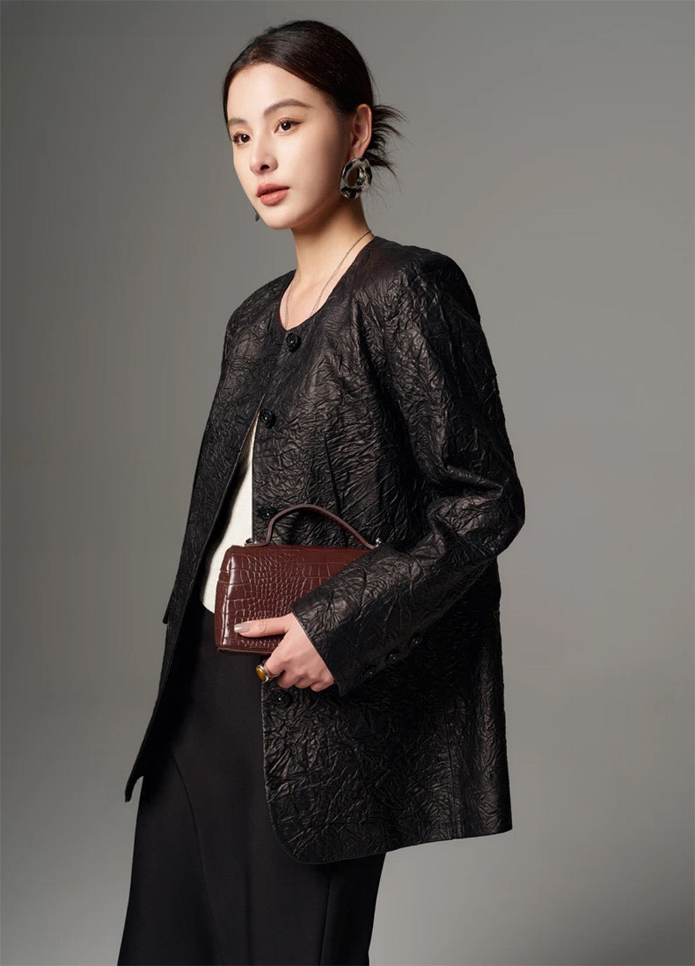 Three-quarter profile of a model wearing a women's crinkled full-grain sheepskin jacket in Crinkled Nocturne — From Borcelleclothes.