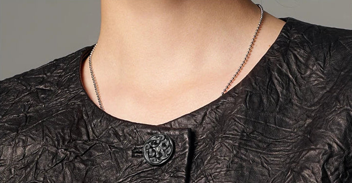 Close-up of the clean, collarless round neckline on a women's crinkled full-grain sheepskin jacket — From Borcelleclothes.