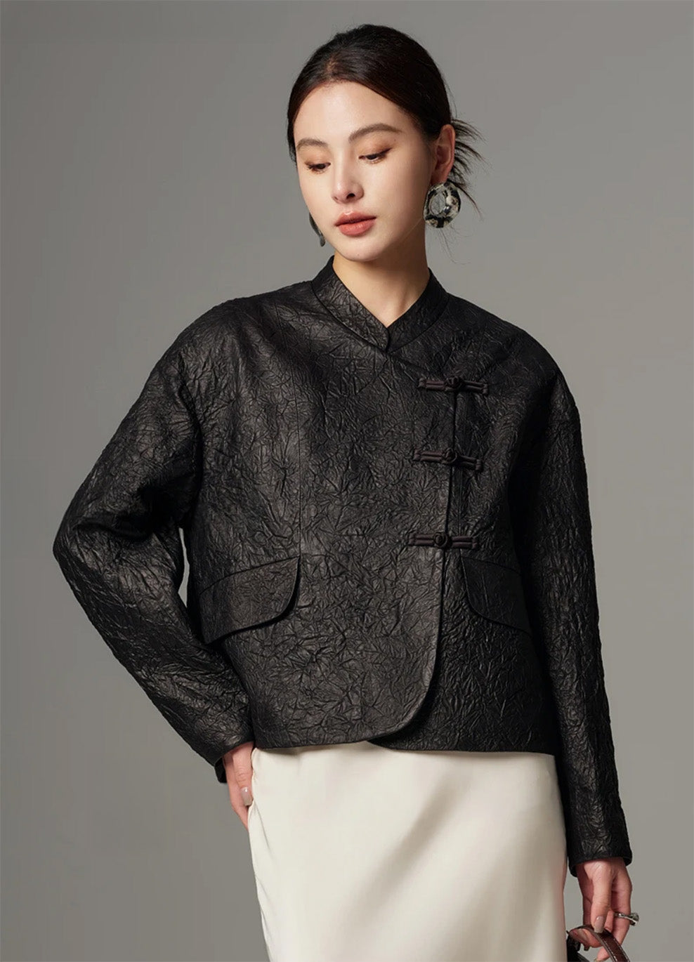 Model wearing the Frost-Glazed Lava crinkled sheepskin pankou jacket with one hand resting on her hip, accentuating the asymmetrical wrap silhouette — From Borcelleclothes.