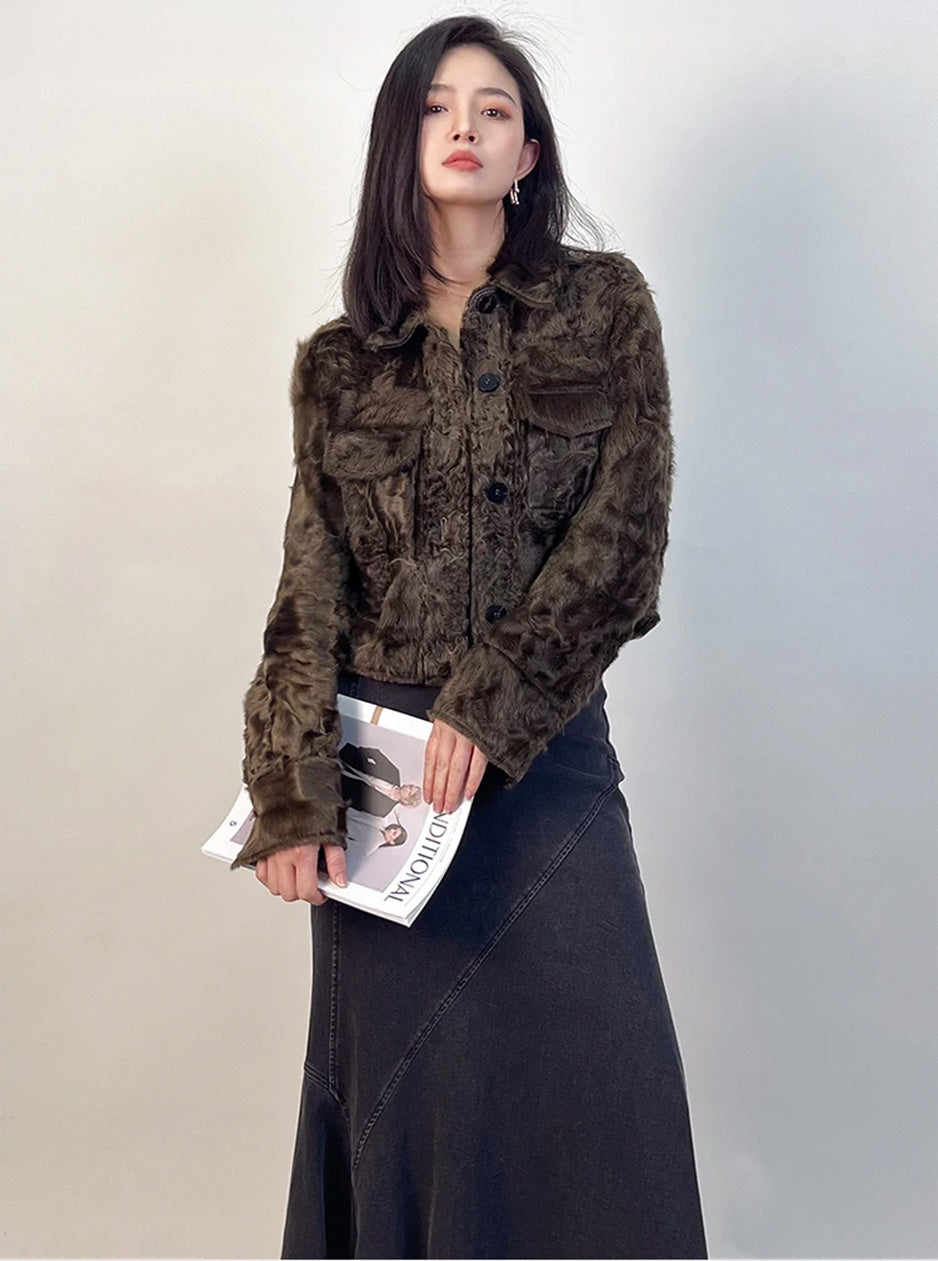 The Star Anise shearling shirt-jacket framed by a journal held in both hands, focusing on the flared cuffs and the soft glow of the fibers. — From Borcelleclothes.
