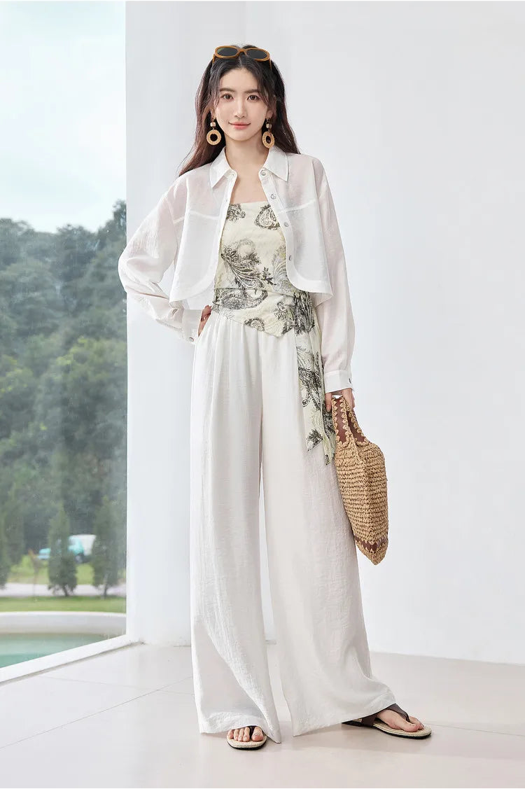 Woman posing in the Alabaster Mirage set with an unfastened shirt, highlighting the matte, stone-like texture of the white linen-blend. From Borcelleclothes.
