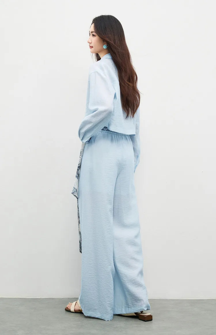 Rear view of a woman in the Lapis Shimmer set, showcasing the deep back yoke and clean lines of the cropped shirt. From Borcelleclothes.