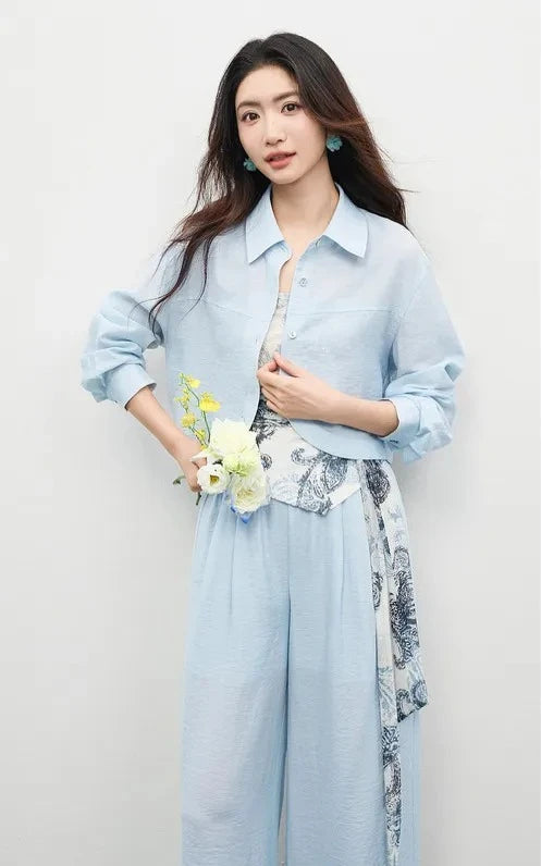 Woman in the Lapis Shimmer set holding a bouquet, emphasizing the romantic and breezy nature of the linen-blend fabric. From Borcelleclothes.