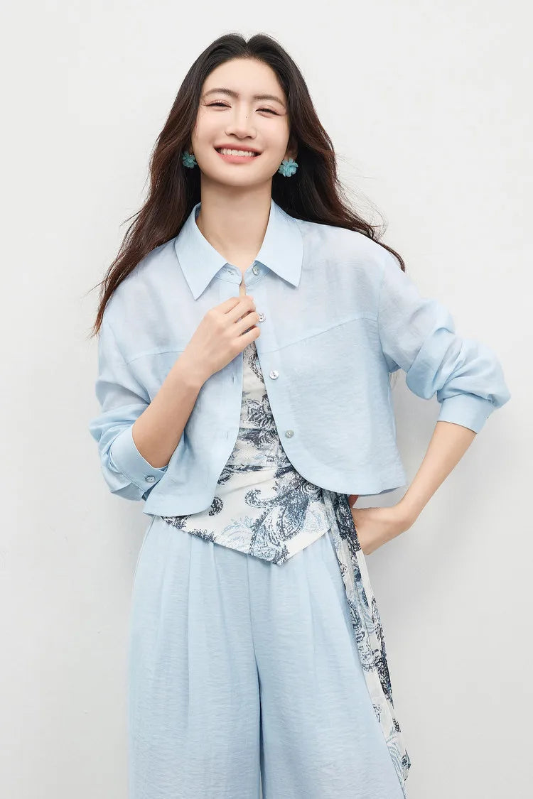 Woman wearing the Lapis Shimmer set with an unfastened shirt, emphasizing the architectural layers of the ensemble. From Borcelleclothes.